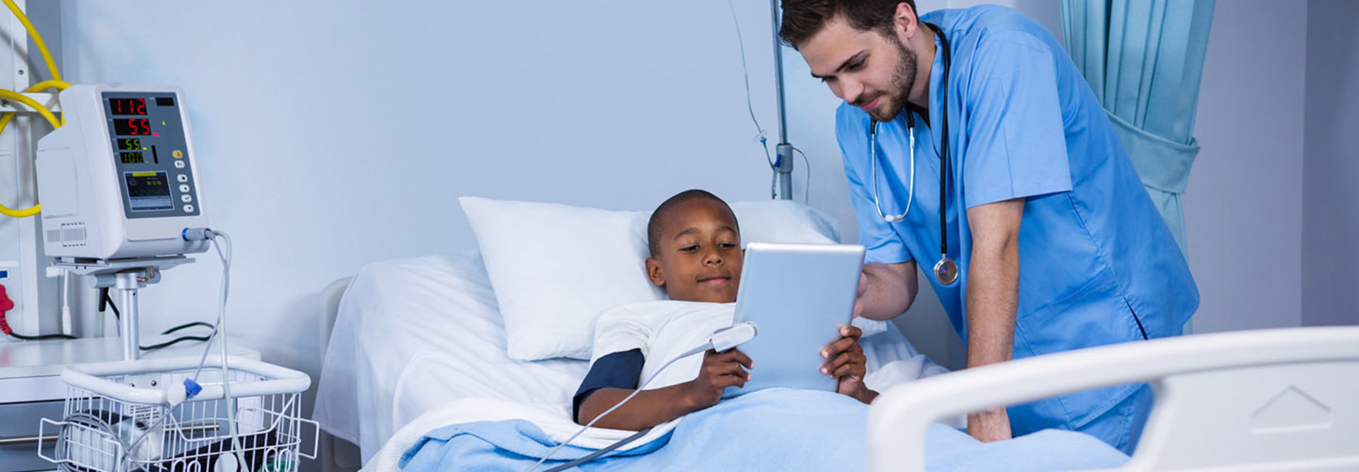 Male nurse and patient using digital tablet in ward