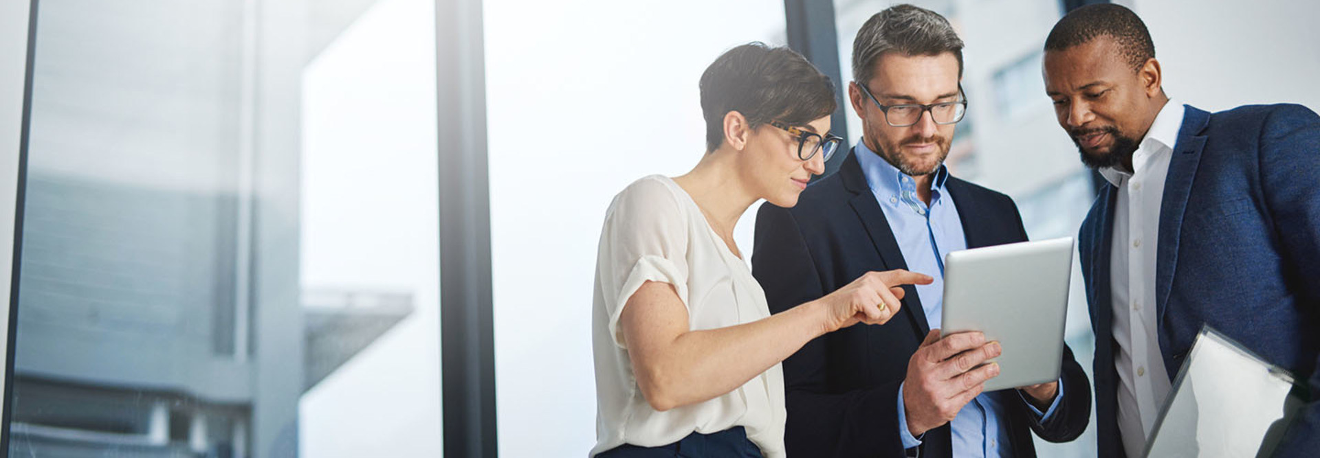 Shot of a team of colleagues using a digital tablet together at work
