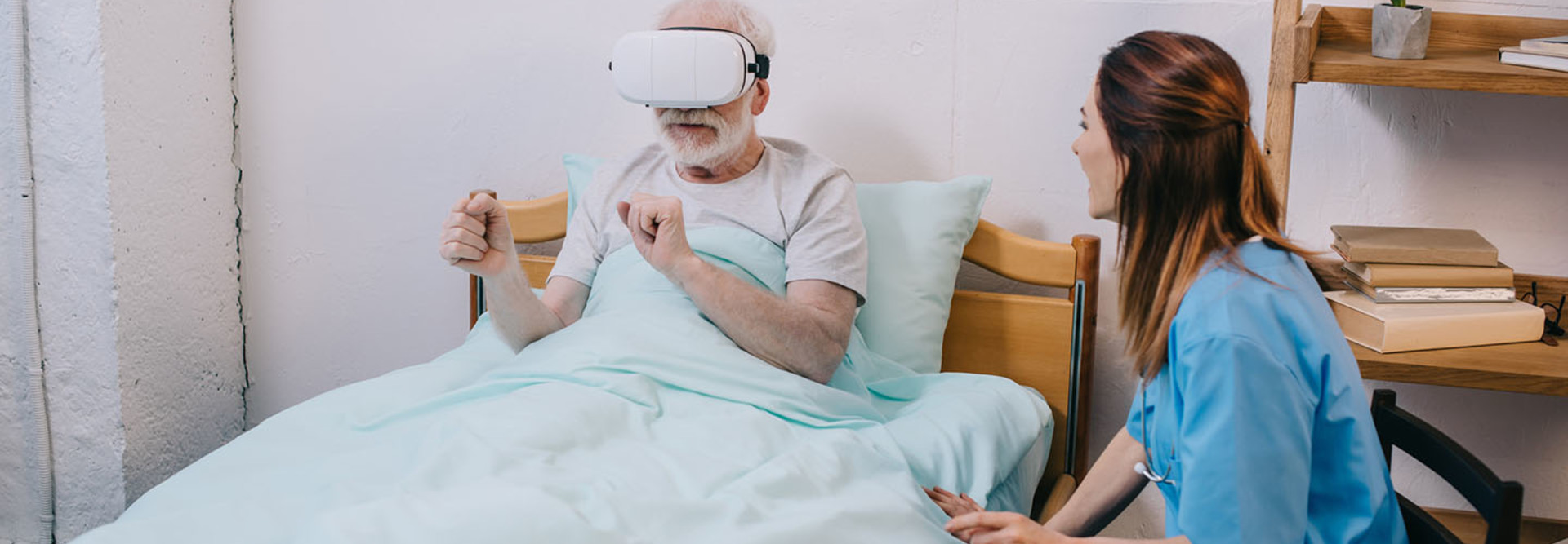 Nurse sitting by patient using VR headset
