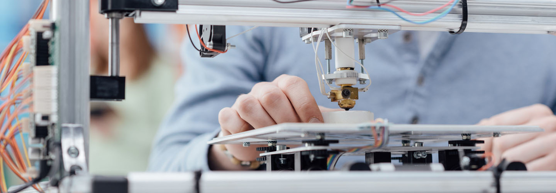 Engineering student using a 3D printer in the lab and printing a prototype