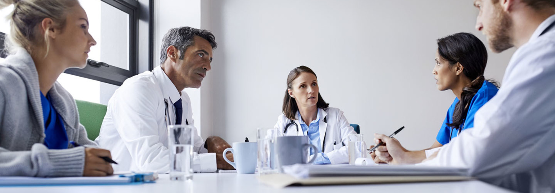 Surgeons discussing at table in board room