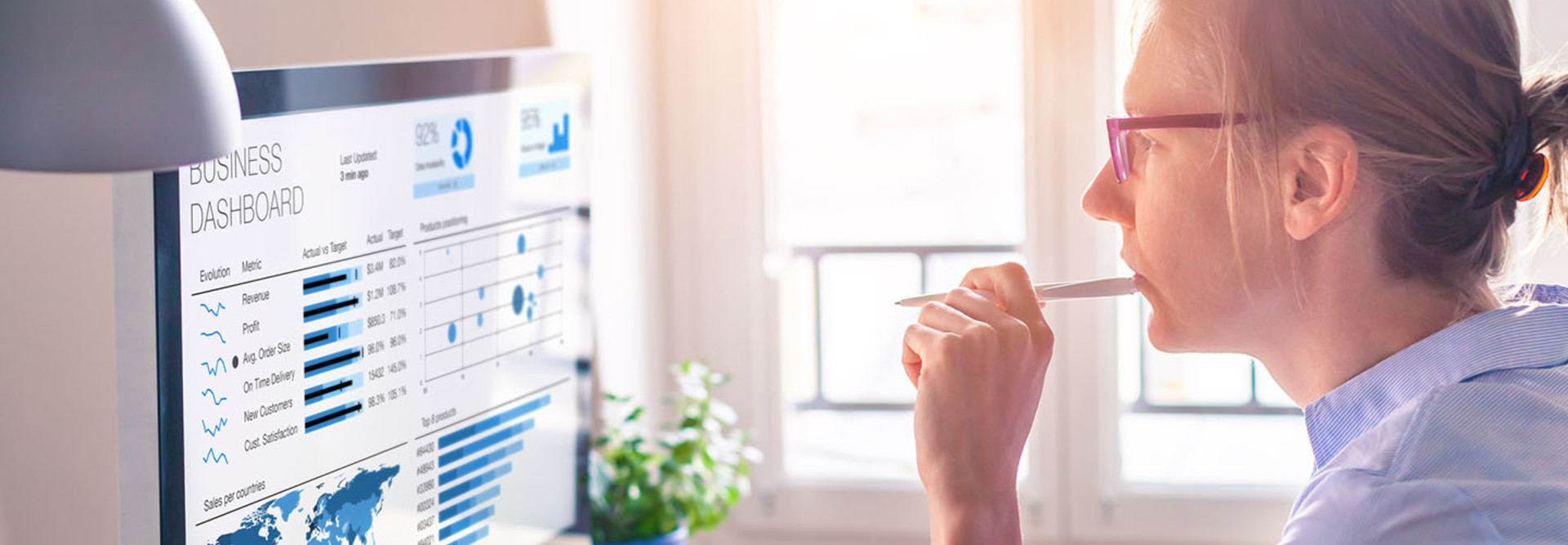 Businesswoman using business analytics or intelligence dashboard on computer screen