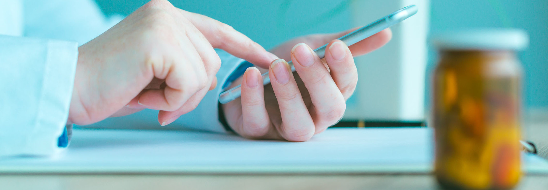 General practitioner using smartphone in office