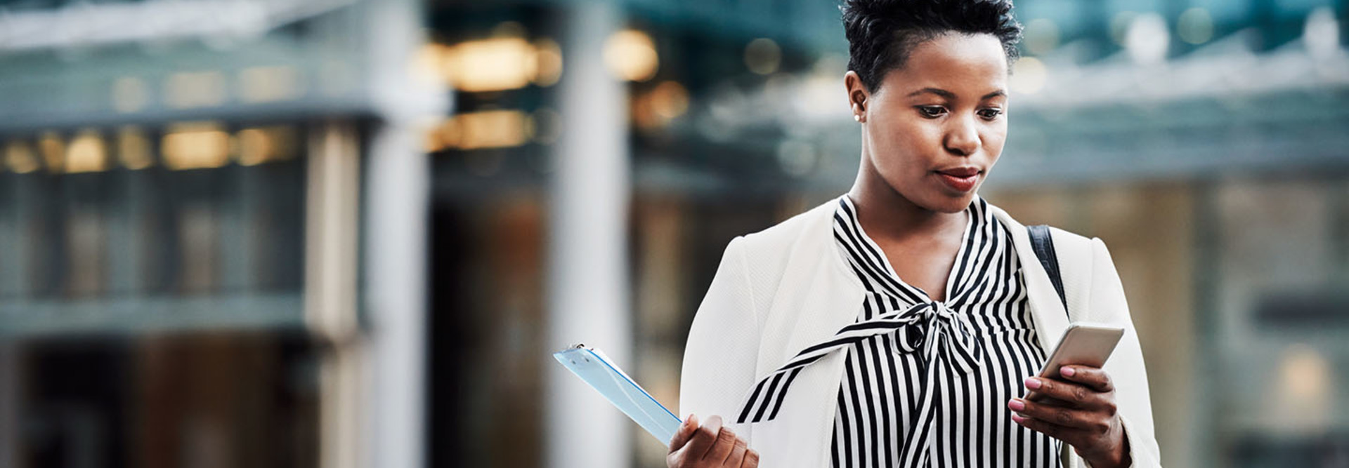 Shot of a young businesswoman using a mobile phone on the go in the city