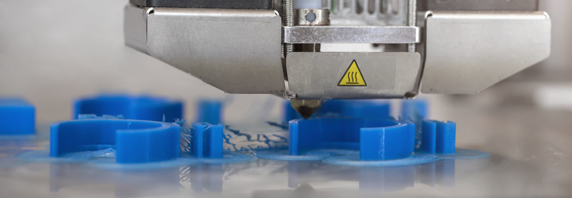 A 3D printer printing prototypes in a biomedical classroom laboratory, close up view.