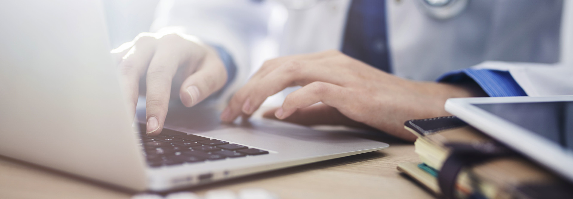 Doctor uses laptop.