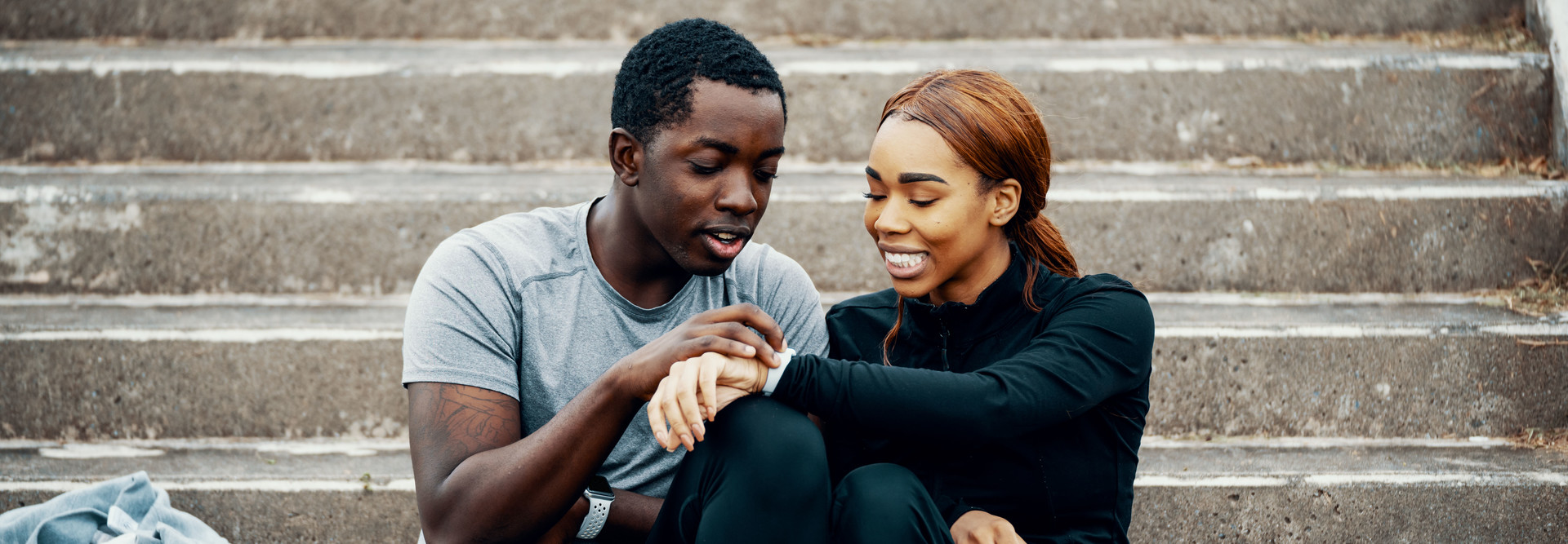 Man and woman look at smartwatch