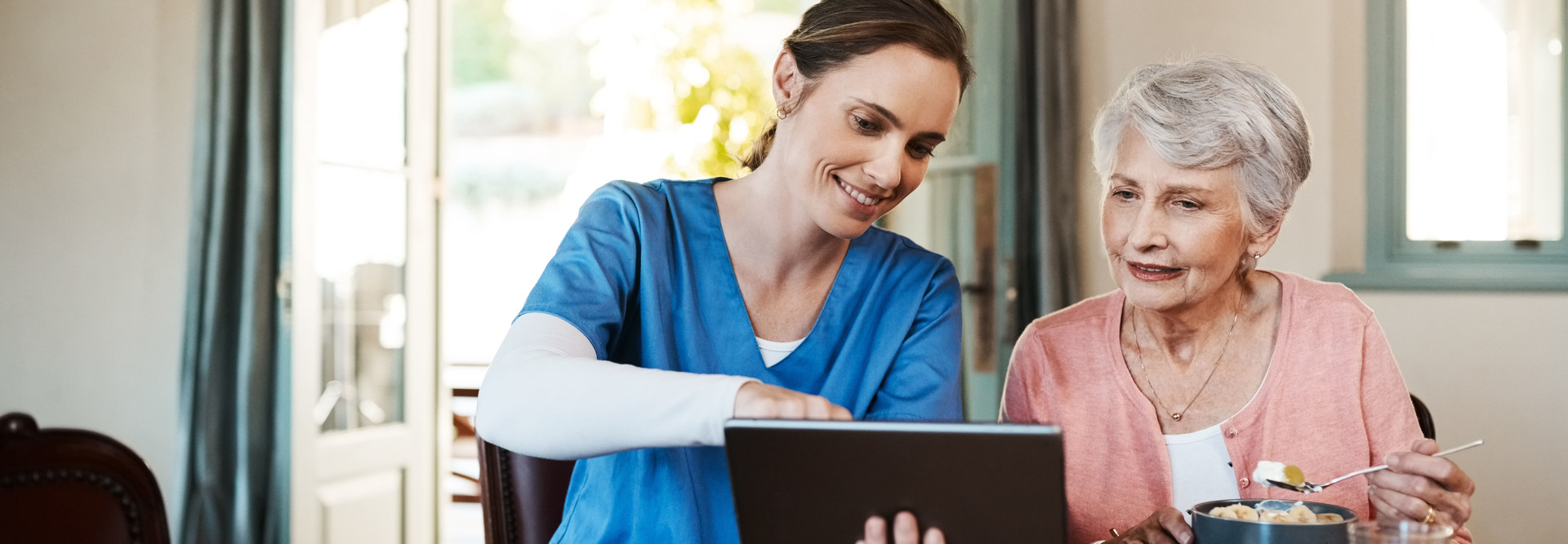 nurse and older adult with tablet