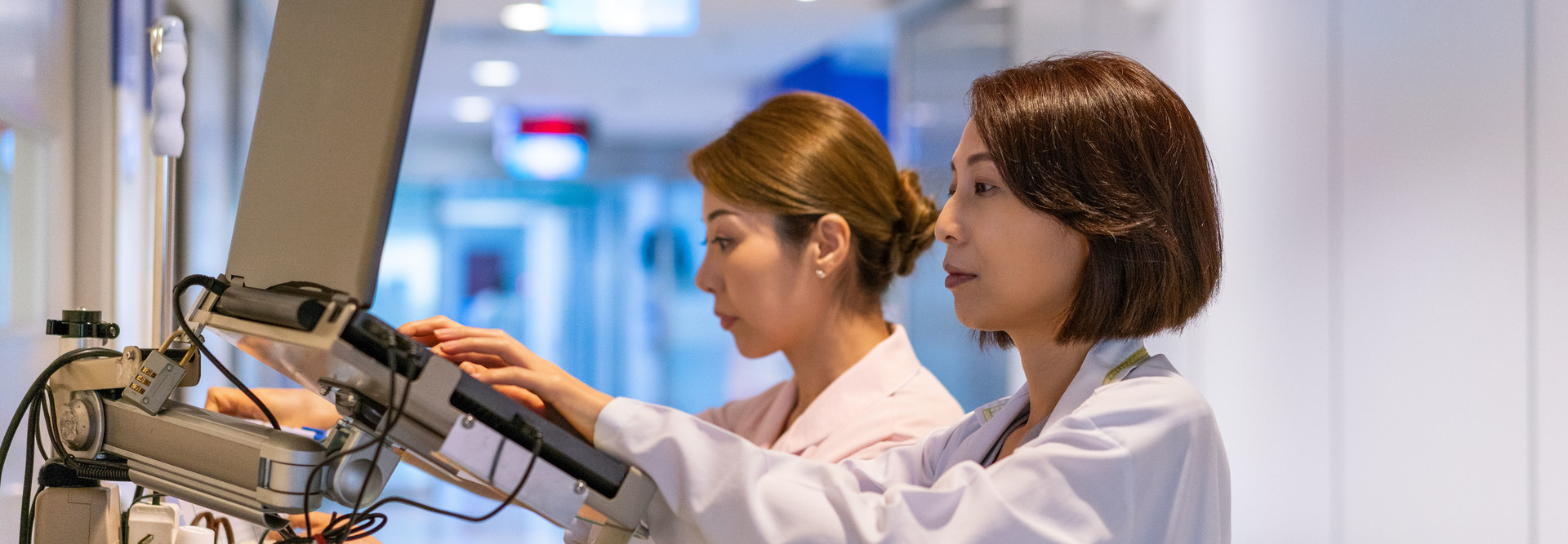 Doctor types at mobile EHR workstation