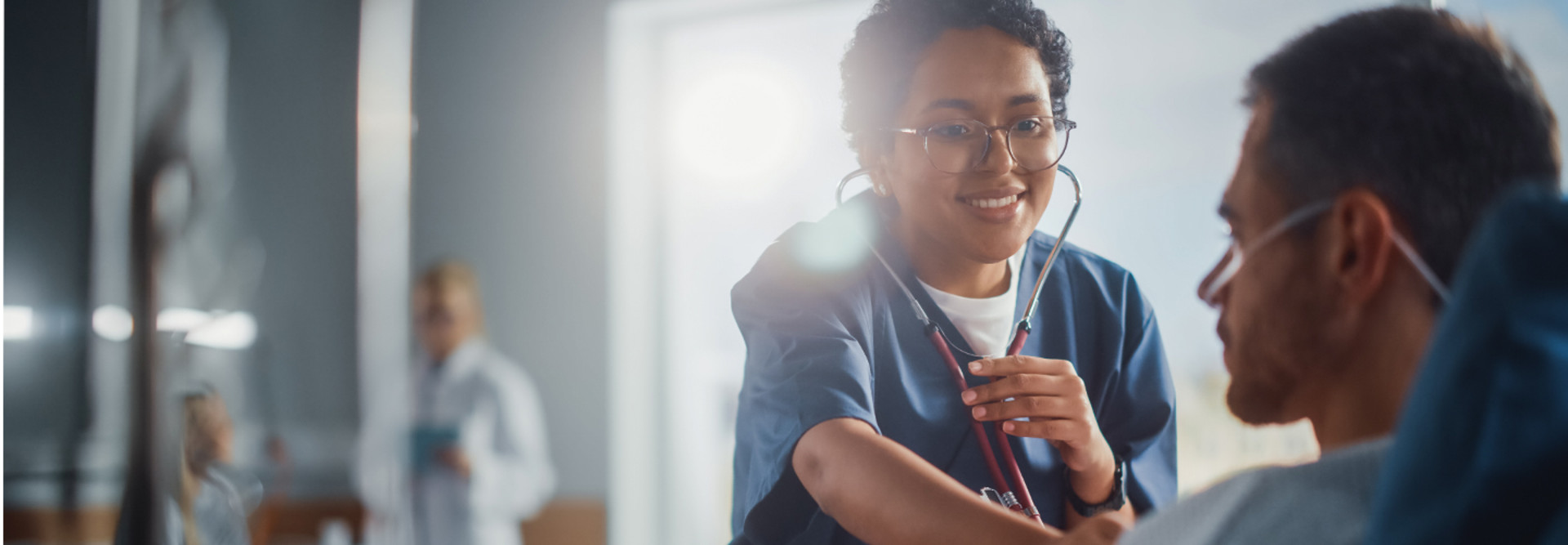 female nurse checks heartbeat of male patient using stethoscope
