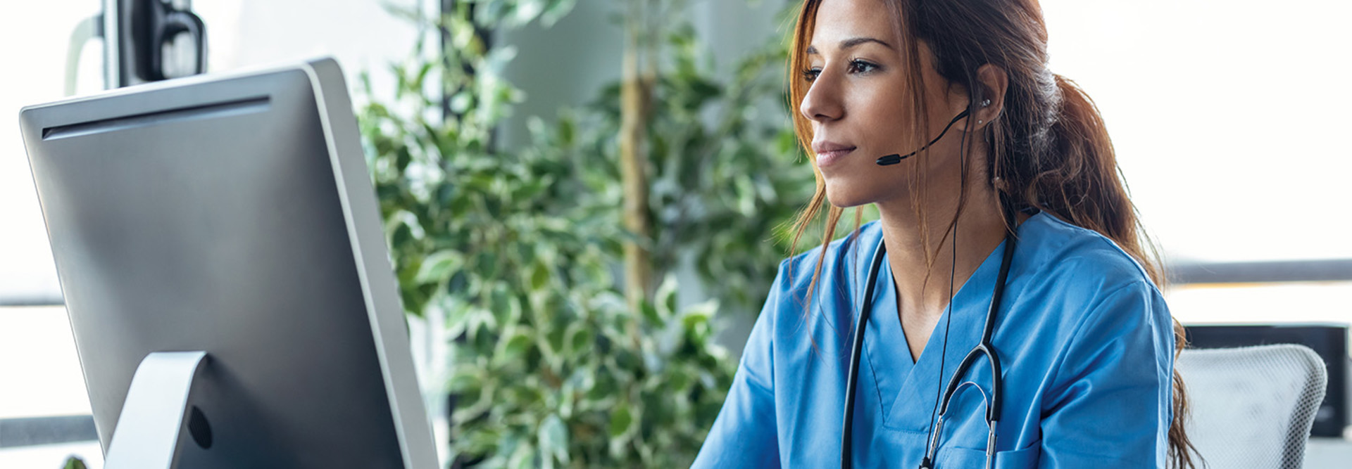nurse monitors patients on computer - telesitting concept