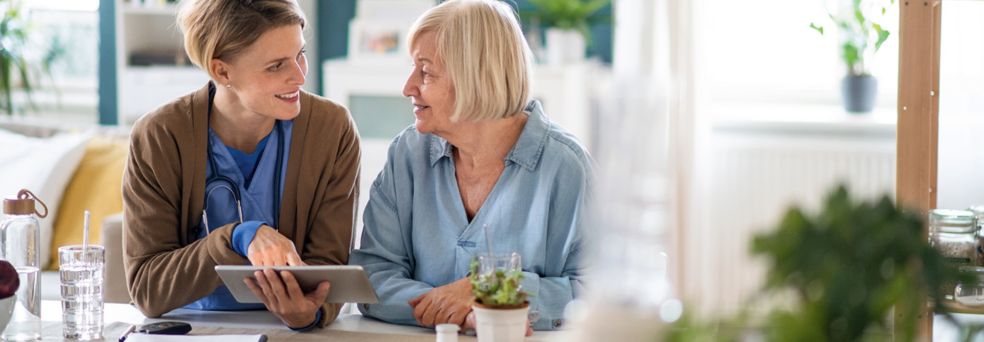 nurse and older adult look at tablet