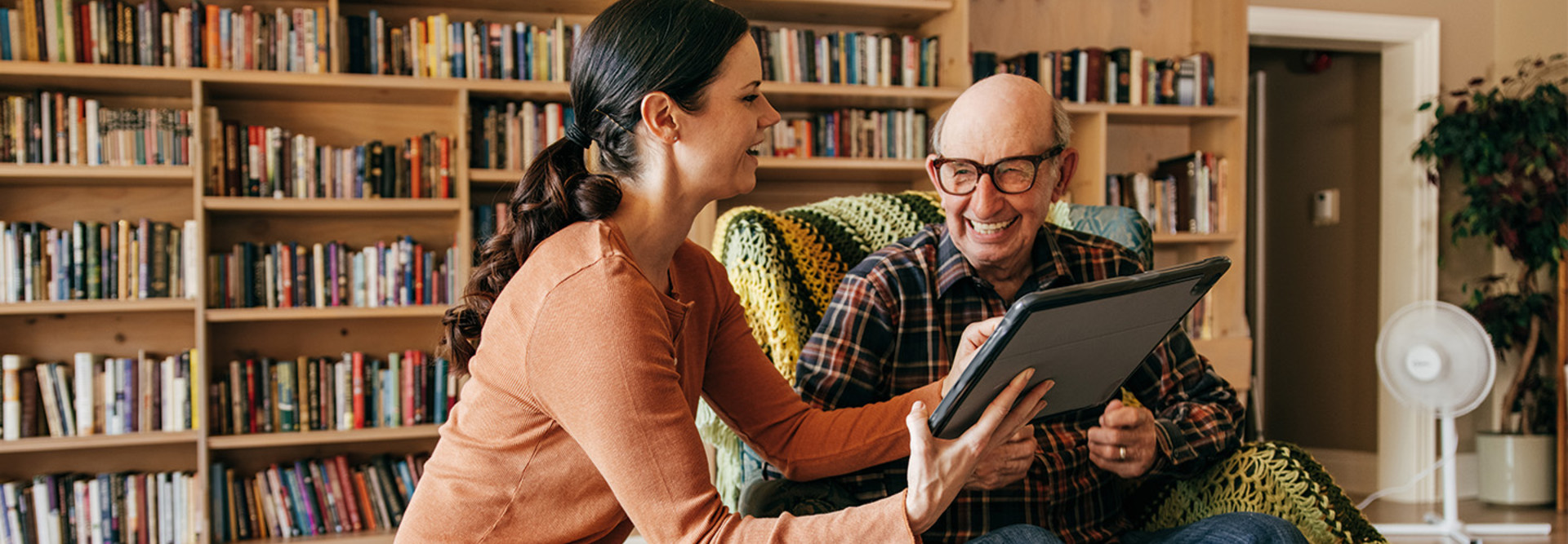 caregiver and senior use tablet together