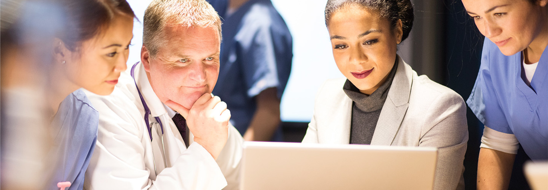 healthcare and IT leaders collaborate over laptop