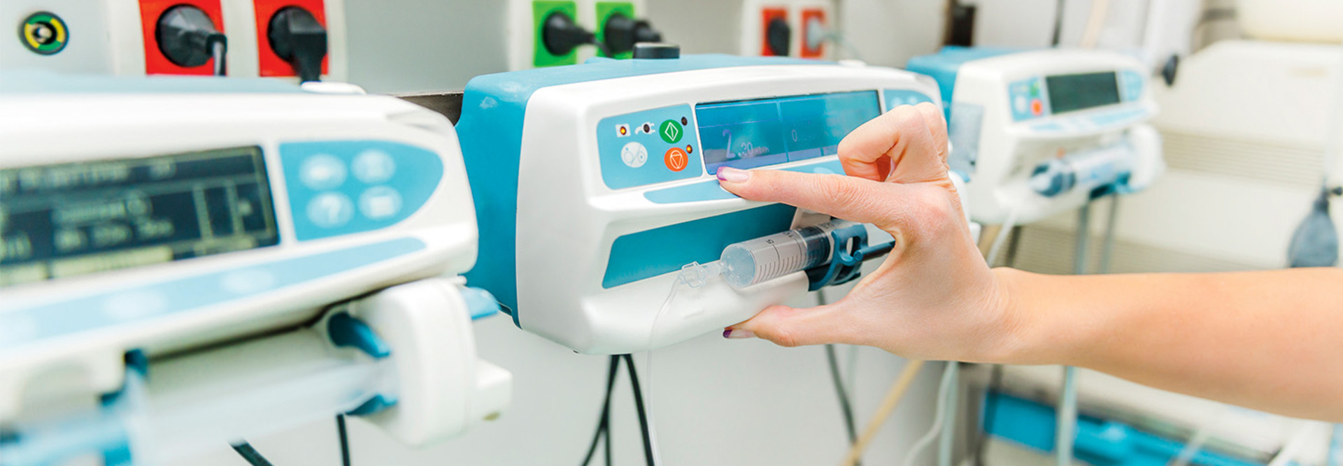 hand presses button on infusion pump in a hospital