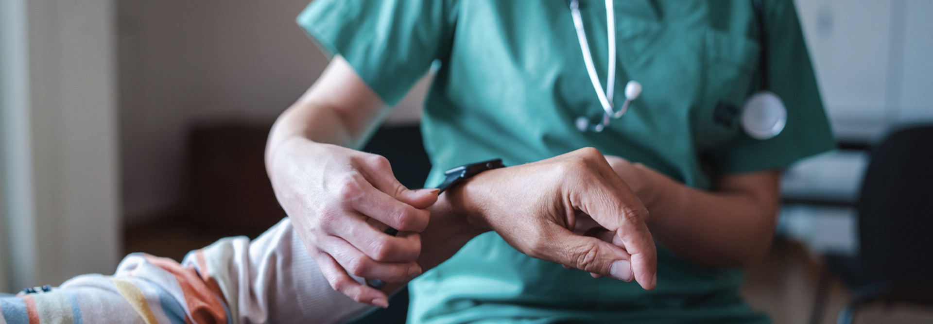 Nurse fitting patient with monitoring technology