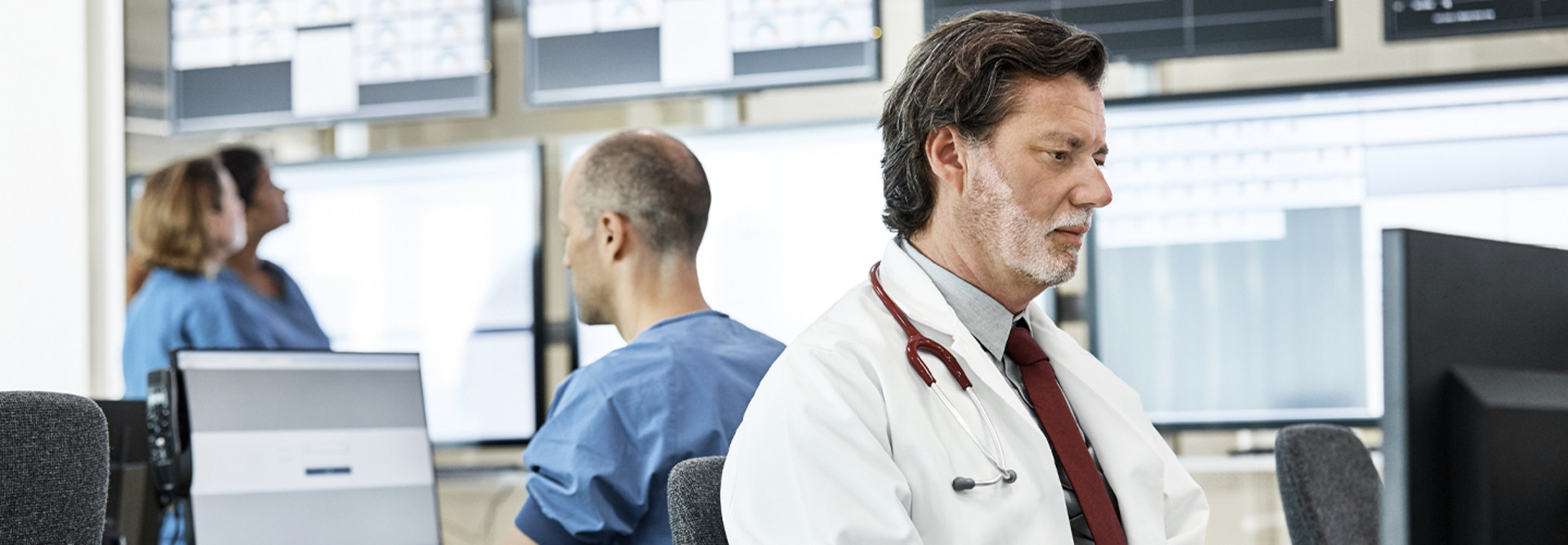 Doctors using computers in control room