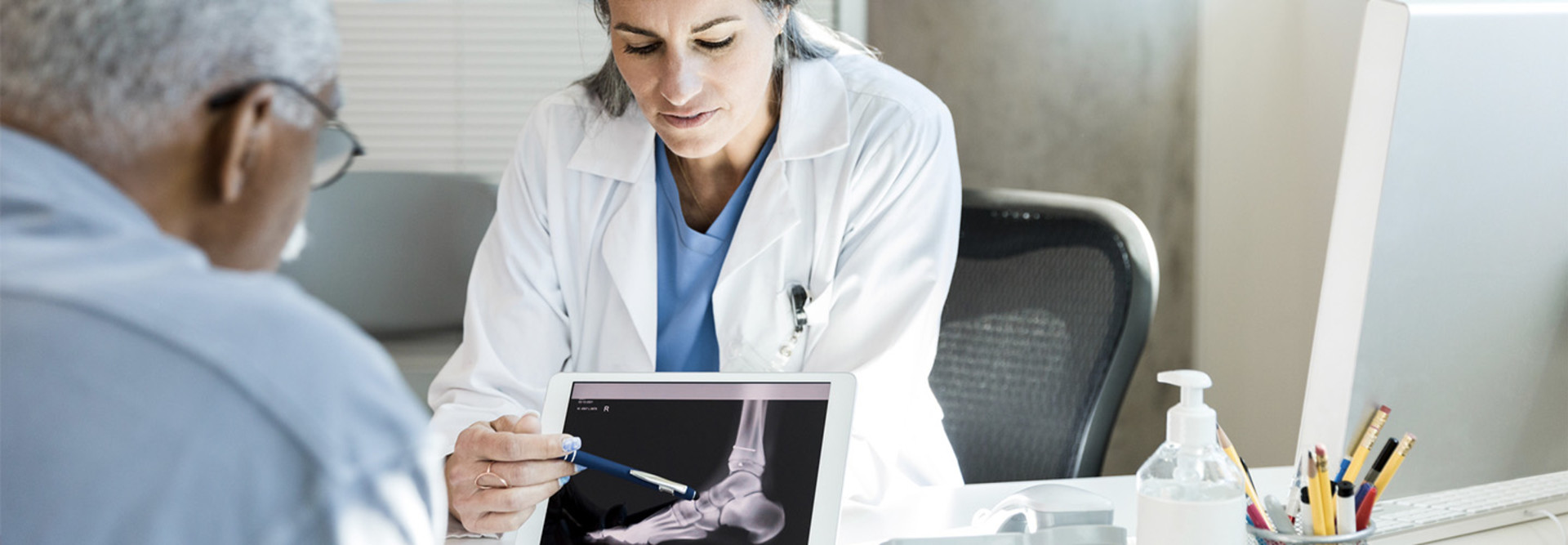 Doctor using tablet with patient 