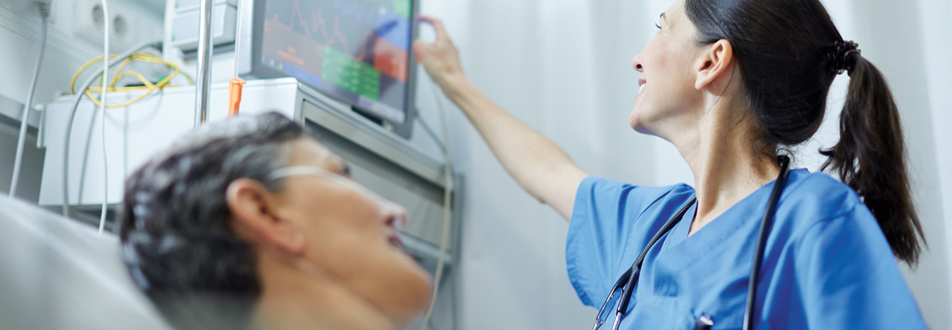nurse checks on patient's vitals