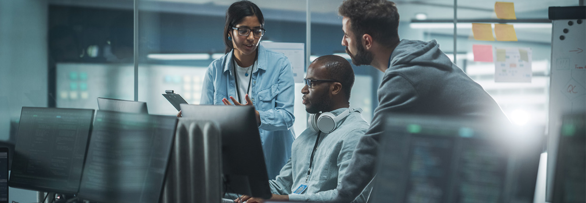 three security team members having a discussion over computer