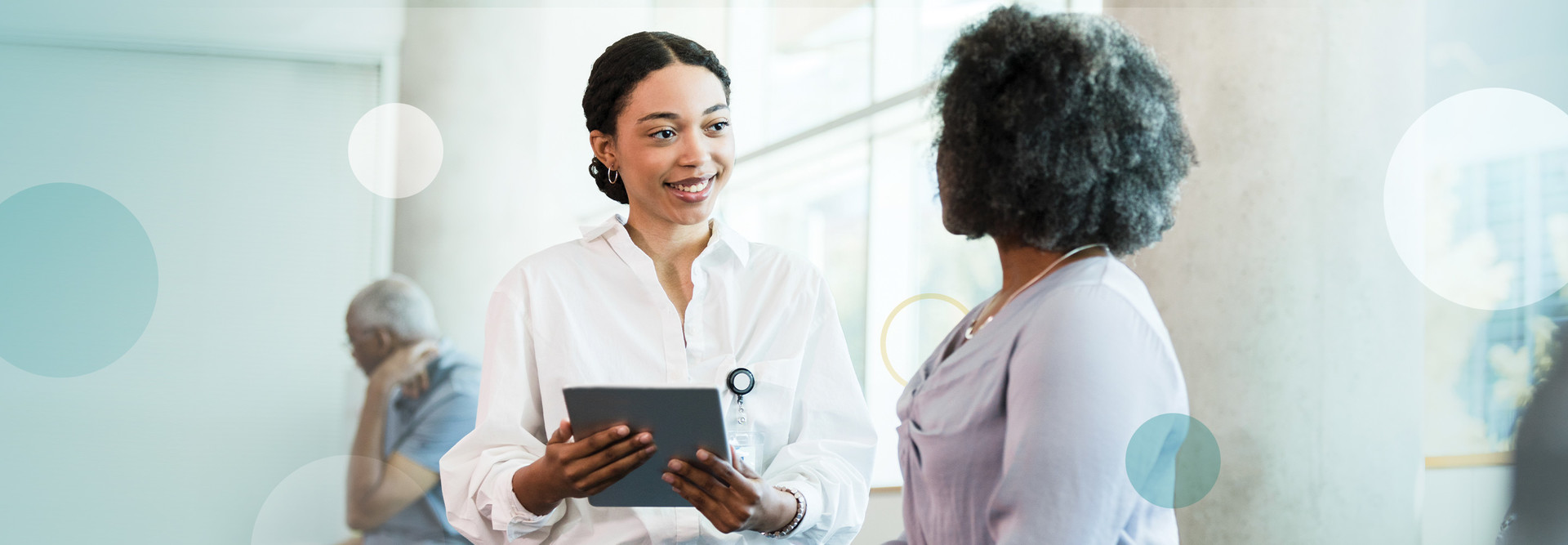 clinician talks with patient while holding tablet