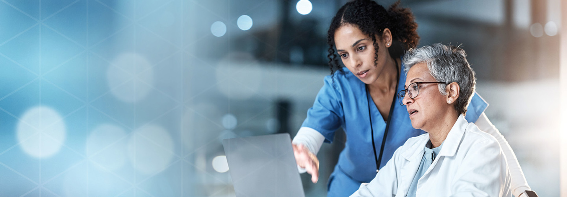 nurse and physician collaborate over laptop