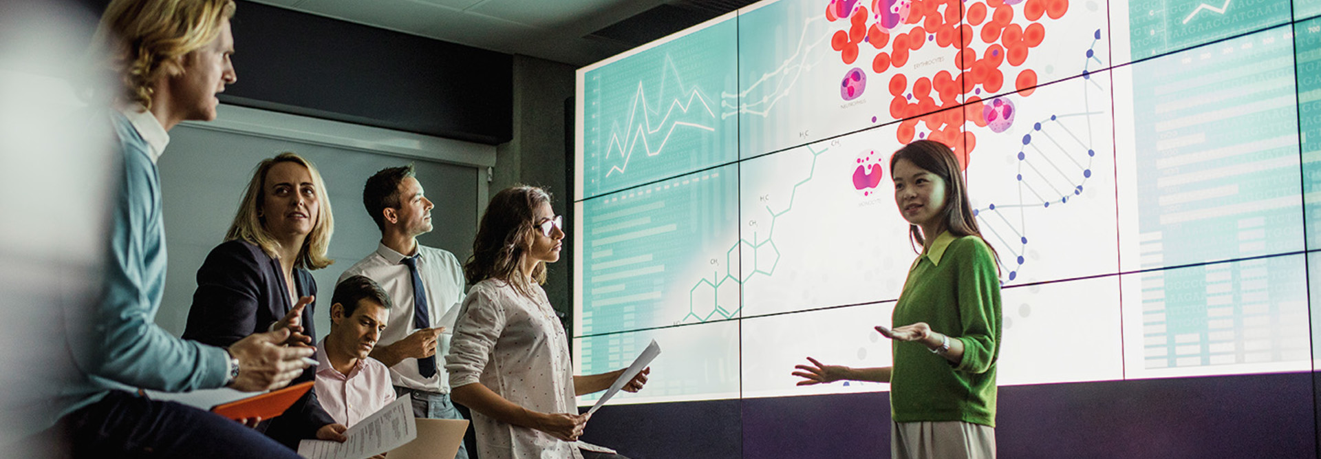 group of scientists look at medical information on a large screen