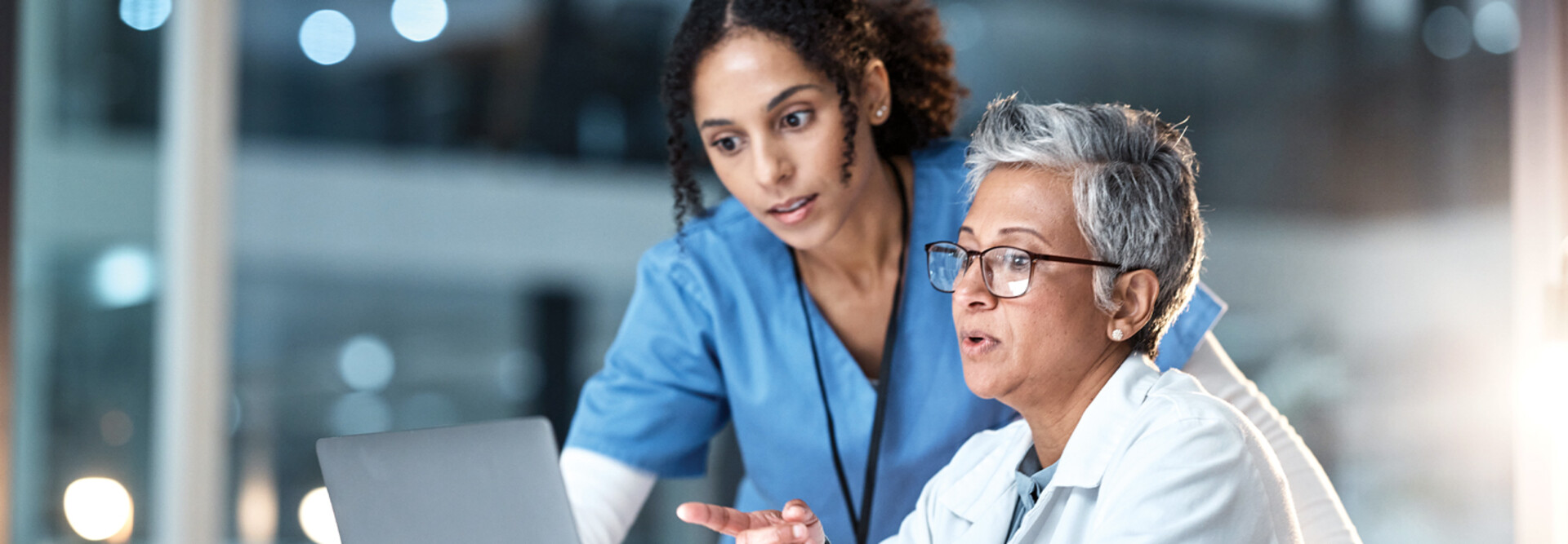 two clinicians looking at laptop
