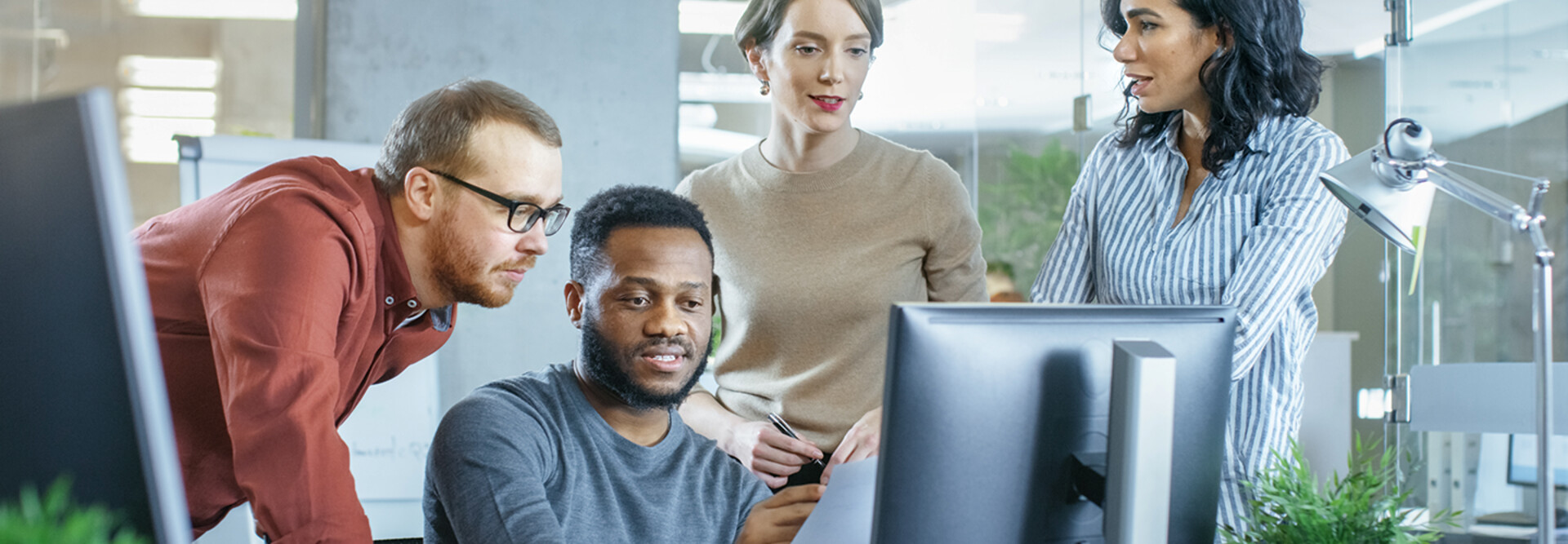 IT team discuss problem around computer