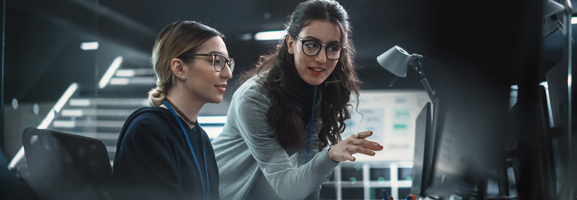 two IT leaders discuss cybersecurity in front of computer