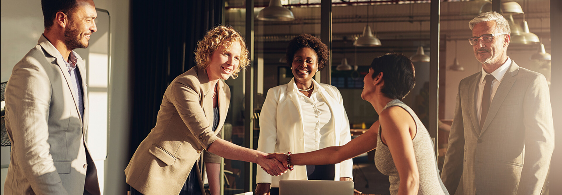 business leaders shake hands in conference room