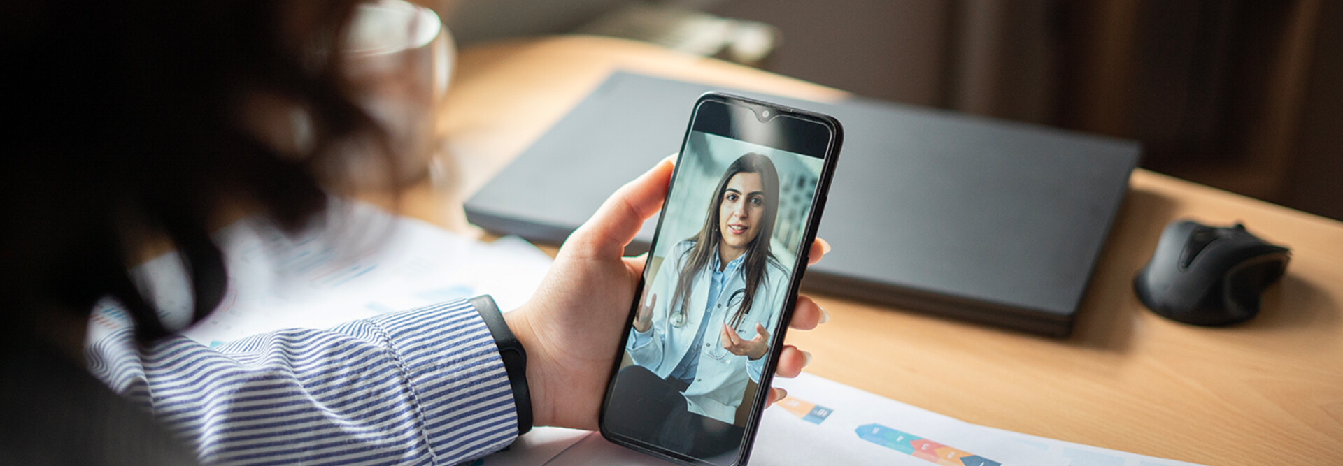 patient holds phone and speaks to doctor during telehealth appointment