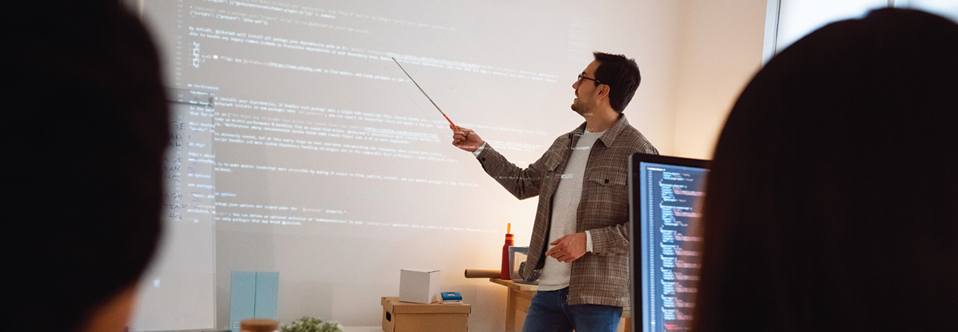 man teaches coding class using projector