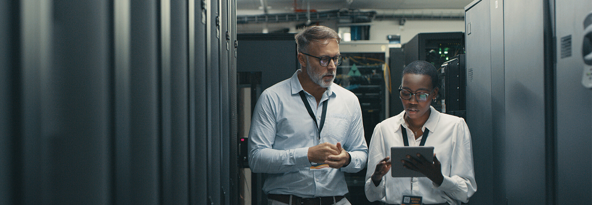 IT professionals look at tablet in data center room