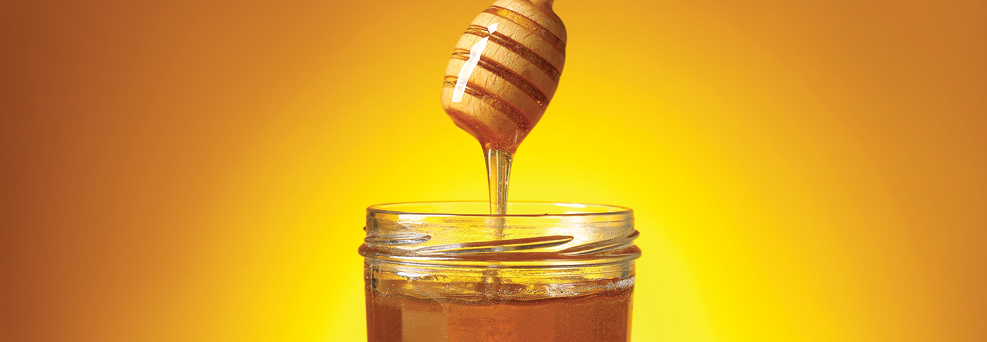 jar of honey with a honey dipper