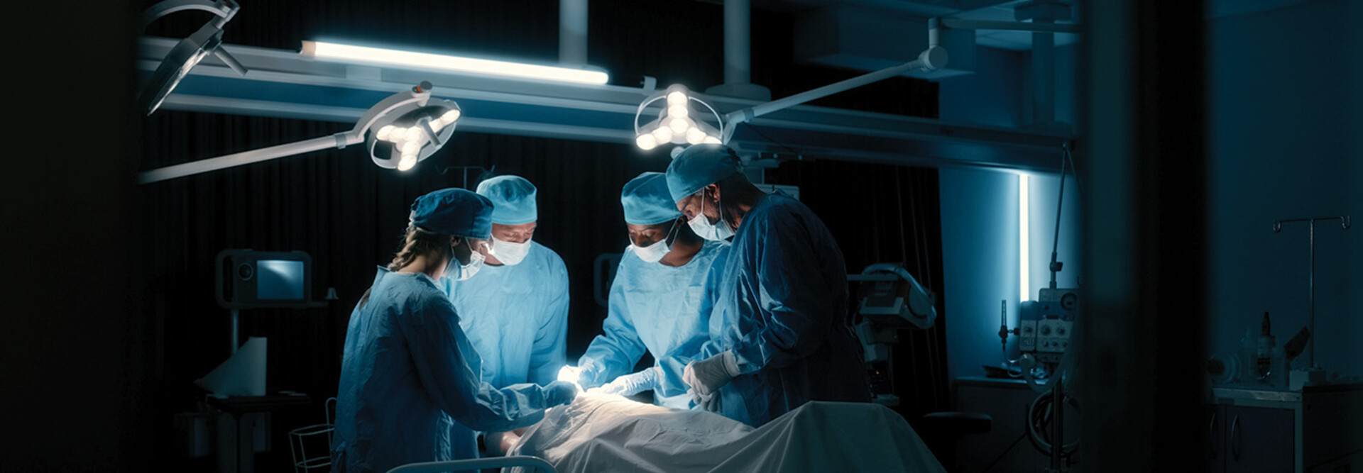 doctors perform surgery in a dark room