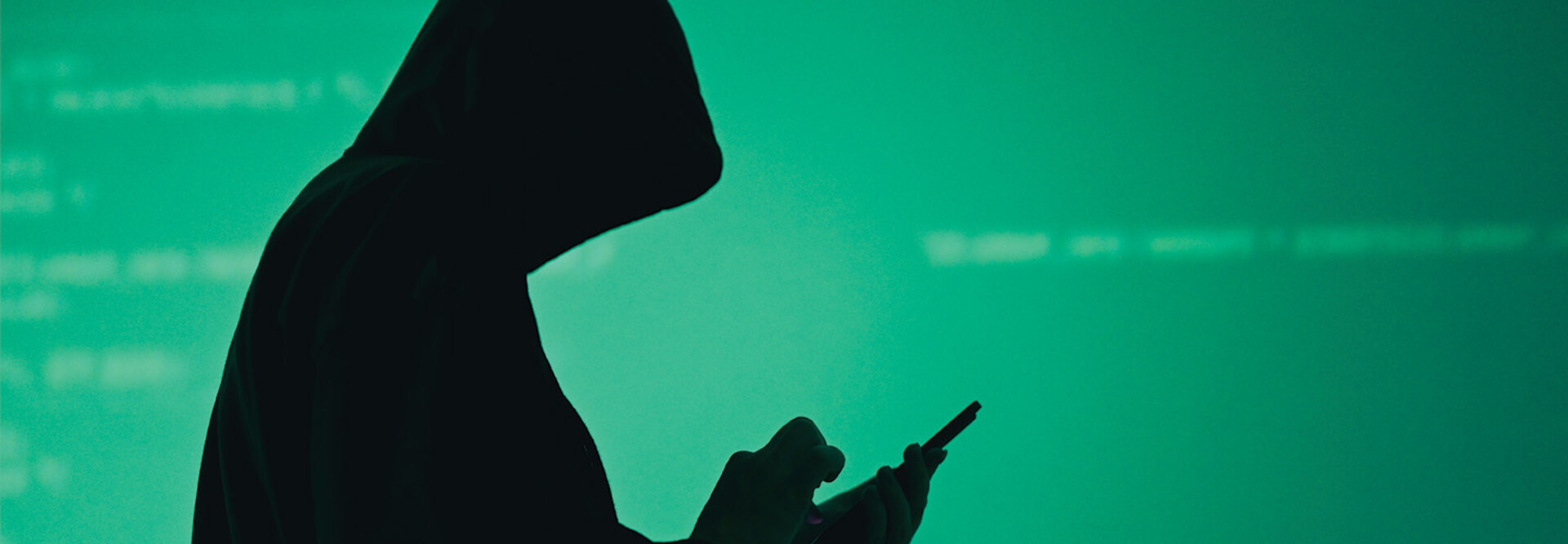 silhouette of hooded figure on phone