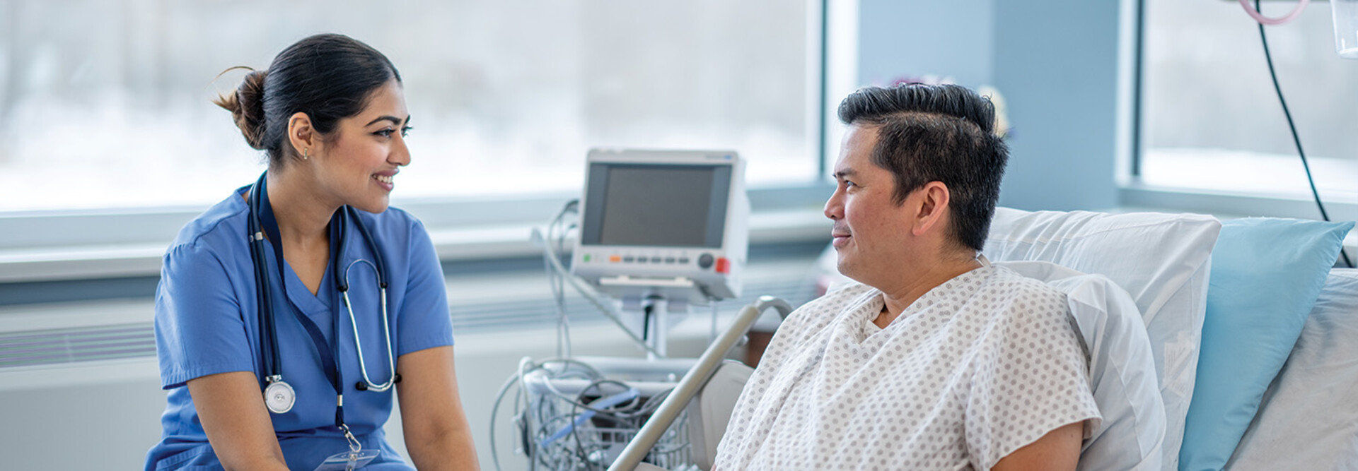 nurse talks with patient in hospital room