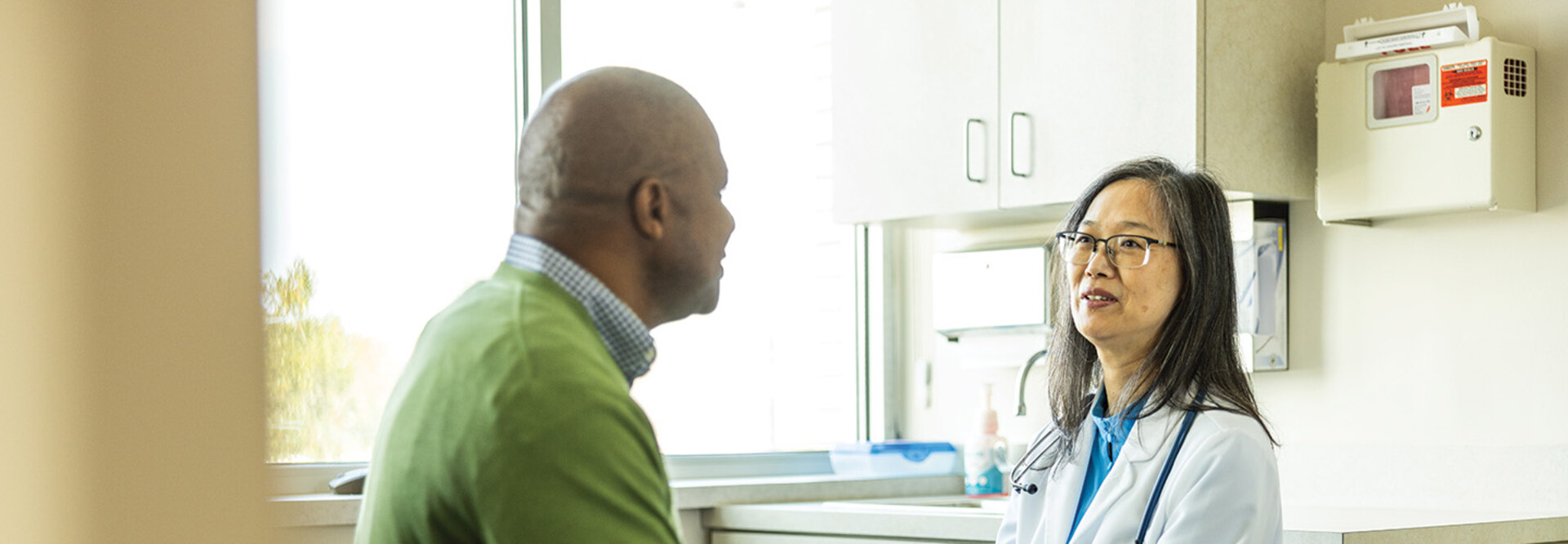 doctor talks with patient in exam room