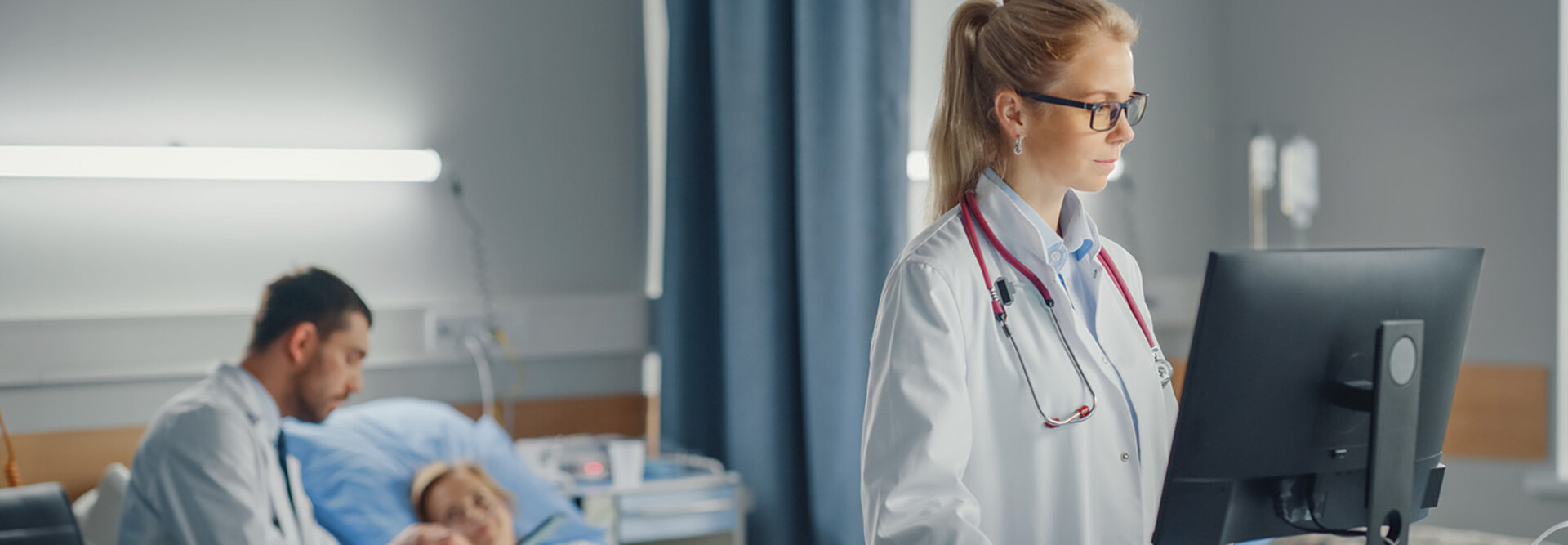 doctor looks at data on computer at the bedside