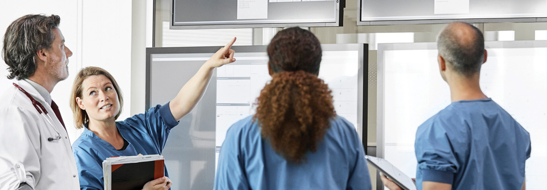 Medical professionals discussing over screens 