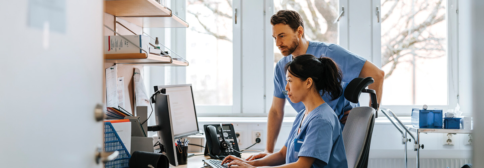 clinicians looking at computer monitor in office