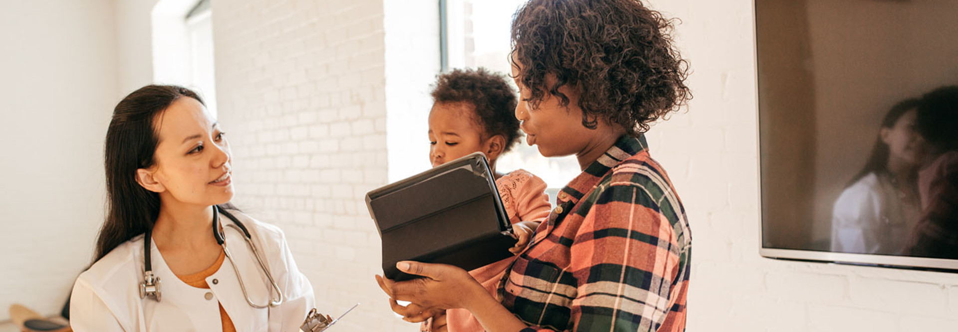  Family doctor attending toddler with iPad