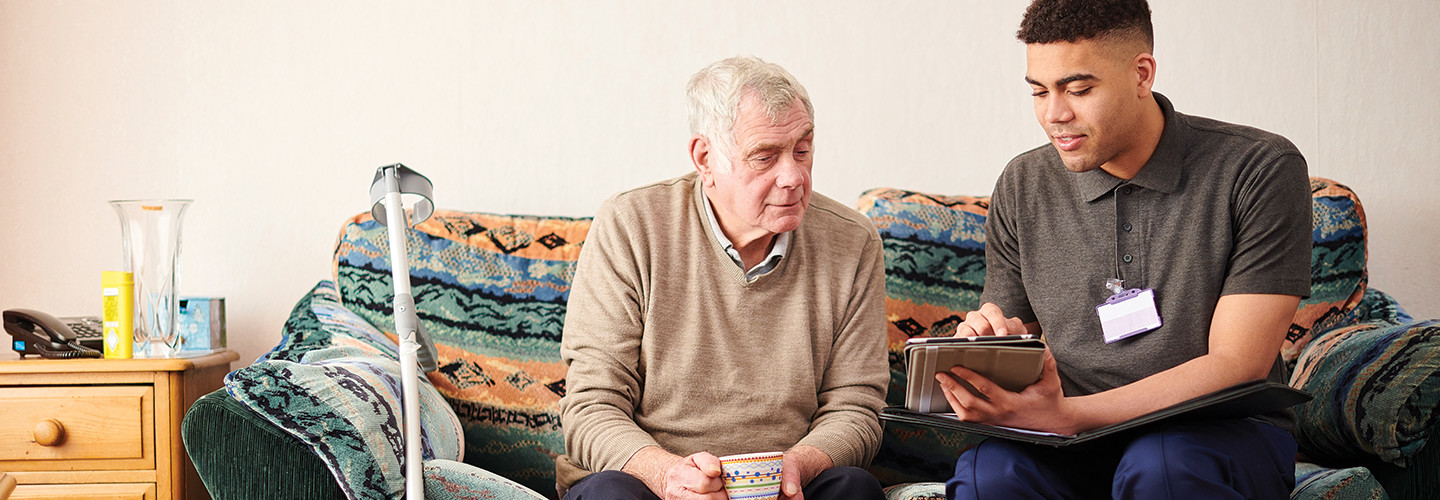Patient and caregiver conferring over a tablet