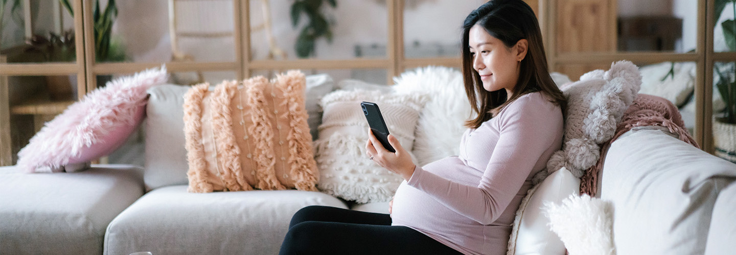 pregnant women looks at app on phone