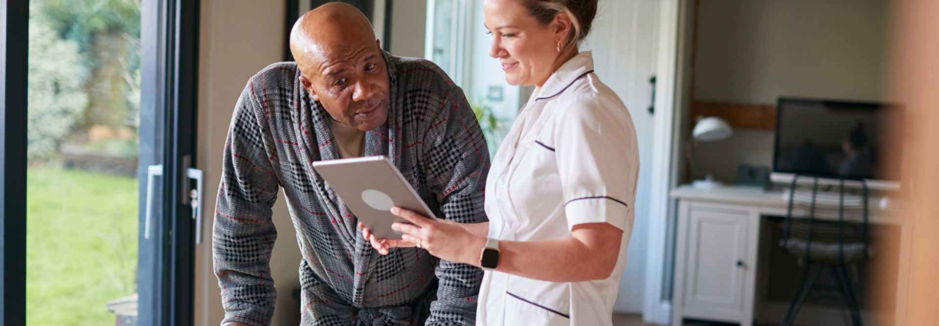 nurse and senior look at tablet together