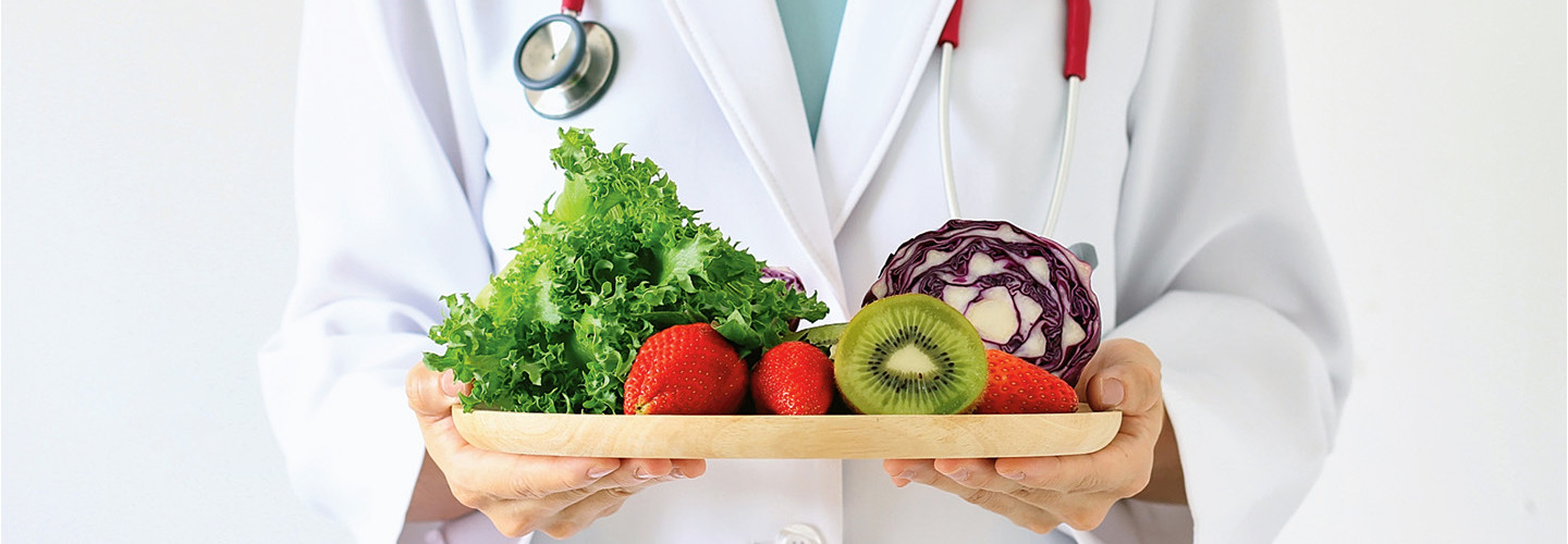 Doctor holds tray of fruit and vegetables