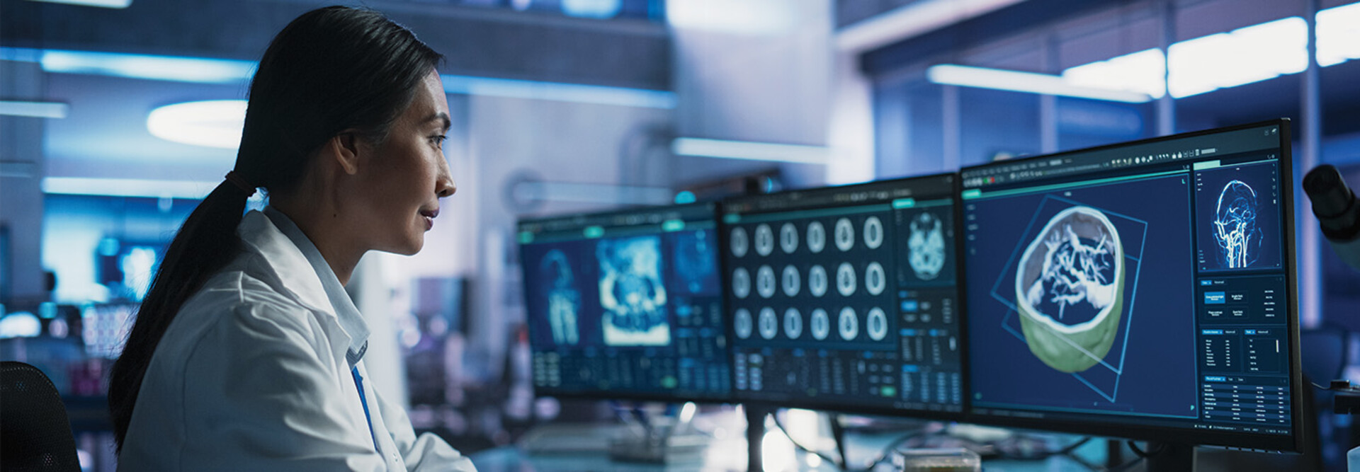 healthcare researcher looks at images and data on monitors