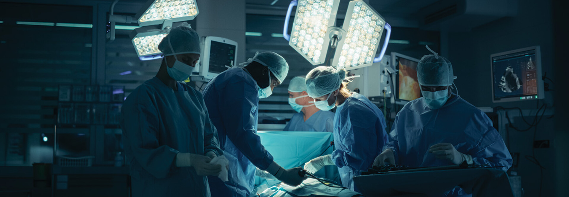 medical team performs surgery in dark room