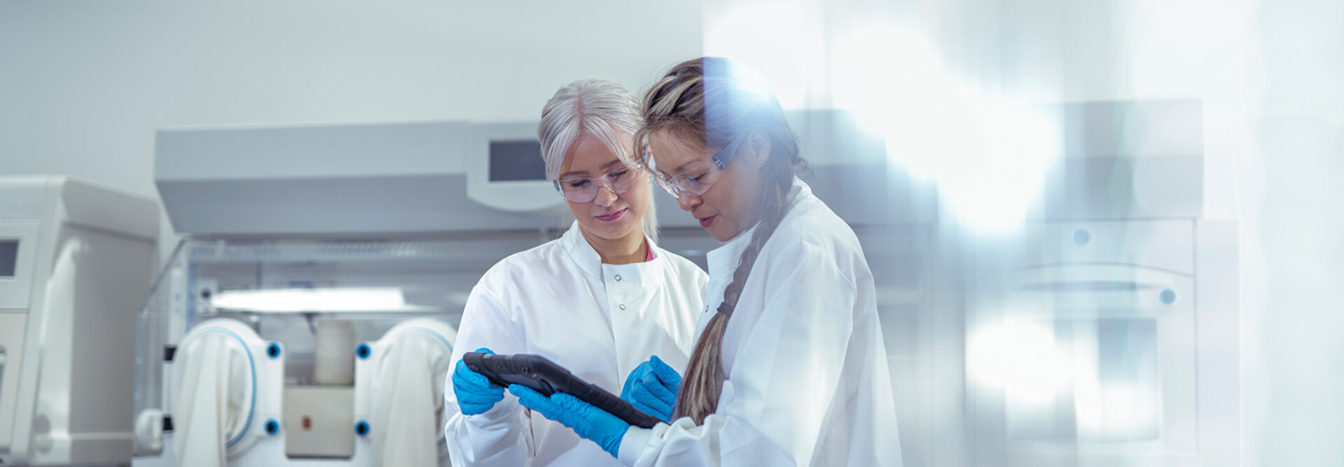 researchers discuss data on tablet in lab